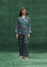 Wearing a pink silk pajama set with bold panther prints.
